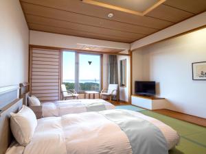 a hotel room with a large bed and a television at KAMENOI HOTEL Aomori Makado in Noheji