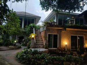 a house with a staircase in front of it at Anodash Homestay in Ban Tai