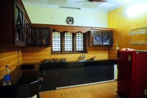 een keuken met een wastafel en een rode koelkast bij Home Near Sabarimala in Rānī