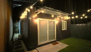 Stylish Container House in Tagaytay - The Manger في Kaybagal: غرفة بحائط مع باب وأضواء