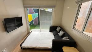 Stylish Container House in Tagaytay - The Manger في Kaybagal: غرفة معيشة صغيرة مع أريكة وتلفزيون