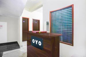 uma secretária de madeira num quarto com uma janela em Hotel O A G M Residency em Sohna