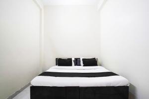 uma cama com lençóis e travesseiros pretos e brancos em Hotel O A G M Residency em Sohna mais 24 fotografias