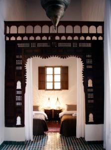 a bedroom with two beds and a window at Dar Seffarine in Fez