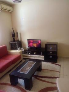 a living room with a red couch and a tv at Ofellows - Kristal Center in Tirana