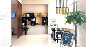 uma sala de estar com uma mesa e cadeiras num quarto em City Comfort Inn Changsha Railway Station Amiling Metro Station em Changsha