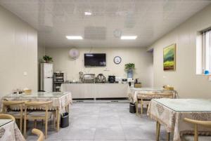 a dining room with tables and a tv on the wall at City 118 Selected Hotel Xi'an Fengcheng Nan Road in Xi'an