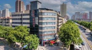 a tall building with trees in front of a city at City 118 Selected Hotel Xi'an Fengcheng Nan Road in Xi'an