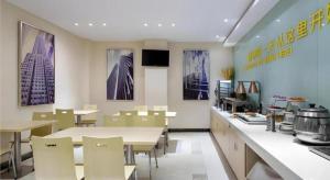 uma cozinha com mesas e cadeiras num restaurante em City Comfort Inn Changsha Xiangya Affiliated 2nd Hospital Yuanjialing Metro Station em Changsha