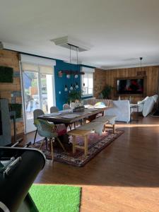a living room with a table and a couch at LA MAISON D'ULYSSE spa et détente in Anould