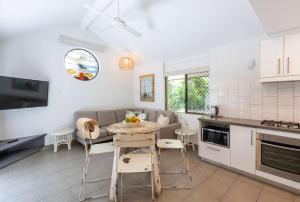 Bayshore Bungalow 5 - Oceanstays في خليج بايرون: مطبخ وغرفة معيشة مع طاولة وكراسي +21 صورة