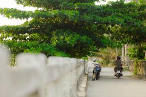 two people are riding motorcycles down a street at Nhà Khách 258 - Sea Front - Near Mikazuki - 500m in Da Nang +26 photos