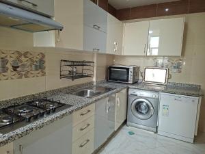 a kitchen with a sink and a washing machine at Résidence Al Qaraouiyine in Fez