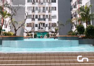 a swimming pool in front of a building at Jarrdin Apartment by CozyNest Syariah in Bandung