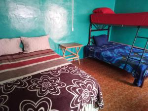 a bedroom with a bed and a bunk bed at El Pacifico Hostel in Juayúa