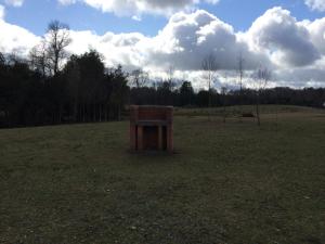 una caja de madera sentada en medio de un campo en Rancho Saeta, en Villarrica