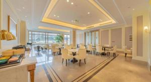 una sala da pranzo con tavoli e sedie in un edificio di Vienna Hotel Chongqing West Station Square a Chongqing