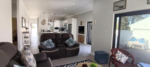 SerenShell House في Stompneusbaai: غرفة معيشة مع أريكة ومطبخ
