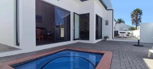 SerenShell House في Stompneusbaai: منزل به مسبح وفناء