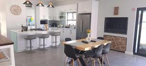 SerenShell House في Stompneusbaai: مطبخ مع طاولة وكراسي وكاونتر