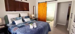 SerenShell House في Stompneusbaai: غرفة نوم مع سرير وحمام مع حوض استحمام +21 صورة