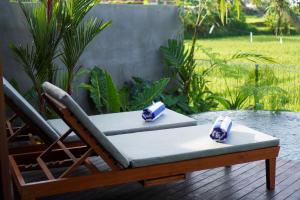 een stoel op een terras met twee servetten bij The Udiana Ubud in Ubud
