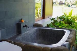 een badkamer met een bad in de tuin bij The Udiana Ubud in Ubud
