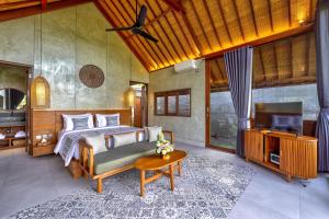 a bedroom with a bed and a flat screen tv at The Udiana Ubud in Tegalalang