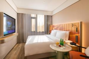 a hotel room with a bed and a table with drinks at Beijing Tiananmen Square Manxin Hotel in Beijing