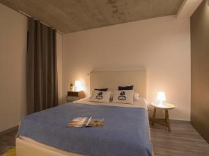 1 dormitorio con 1 cama con manta azul y almohadas en S. Gonçalinho - Suites Apartments, en Aveiro