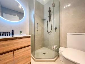 a bathroom with a shower with a toilet and a sink at Brand-New 5BR Retreat, Space & Serenity by Nature in Auckland +51 photos
