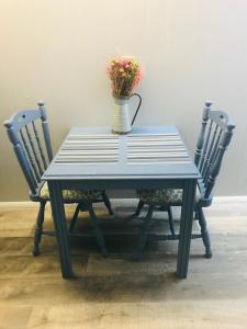a blue table with two chairs and a vase with flowers at Lakeland House in Langley