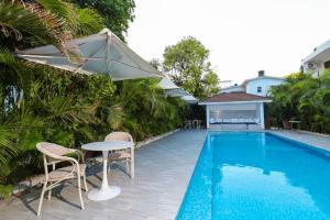 a pool with chairs and a table and an umbrella at 2 bedroom in watamu in Watamu