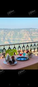 Ein Tisch mit zwei Tellern Essen und Blick auf die Berge in der Unterkunft Lifeline Villas - Wonderment Luxurious Valley Touch 5Bhk Villa With Infinity Pool Close to Strawberry farms in Mahabaleshwar