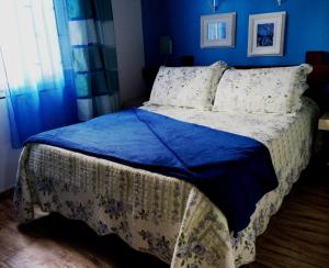 a bedroom with a bed with a blue wall at Chalés Villa Bella in Florianópolis +37 photos