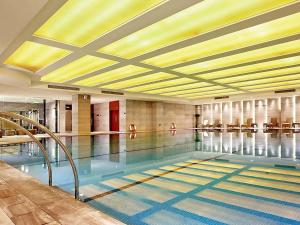 a swimming pool with people in the water at Pullman Xiamen Powerlong in Xiamen