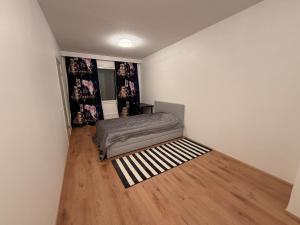a room with a bed and a wooden floor at Helsinki Matinkylä Apartment in Espoo