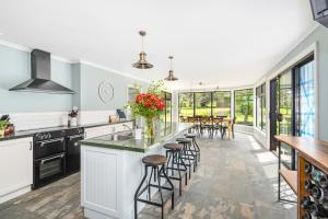 a kitchen with a large island with stools at Farmhouse on the Cradle Coast Forth in Forth