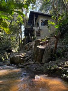 a house on a hill next to a stream at บ้านระเบียงดอยโฮมสเตย์ in Ban Pok Nai