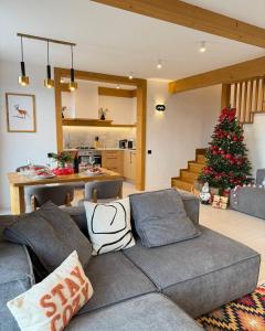 ein Wohnzimmer mit einer Couch und einem Weihnachtsbaum in der Unterkunft Villa Bergbliss in Jablunyzja