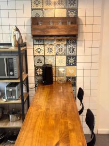 a wooden table in a kitchen with tiles on the wall at Mira Apartments 2BR Apartment in Nadi Free Parking & WiFi in Nadi