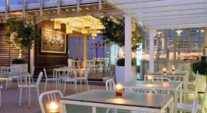 a restaurant with white tables and chairs on a patio at Gajahmada Avara Boutique Hotel in Siantan