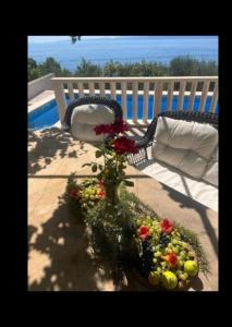 a vase filled with flowers sitting next to a chair at Apartments Villa Suzana Including Private Pool in Selca