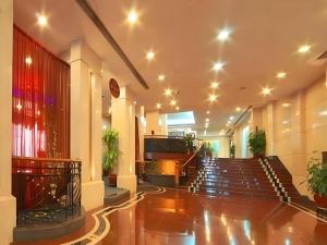 a lobby with stairs and a piano in a building at Friendship Hotel in Shenzhen