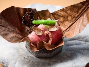 Un montón de comida sobre una mesa con una hoja. en Atami Izusan Karaku, en Atami