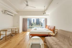 a living room with a bed and a table at Fanhua Life IN Nanjing West Road Store 2 in Shanghai