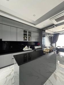 Thiên long homestay في Kinh Dinh: مطبخ بخزائن بيضاء وطاولة عمل سوداء