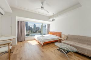 a bedroom with a bed and a couch and a window at Fanhua Life IN Nanjing West Road Store 2 in Shanghai