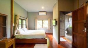 una camera da letto con un letto e una grande finestra di The Frog Khao Yai Resort a Ban Tha Chang