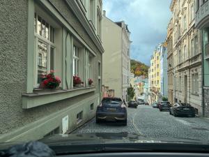 een auto staat geparkeerd in een straat met gebouwen bij Oasis Valley in Karlsbad
